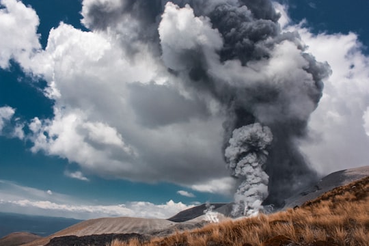 smoke rising towards the sky near brown grass field in Tongariro National Park New Zealand