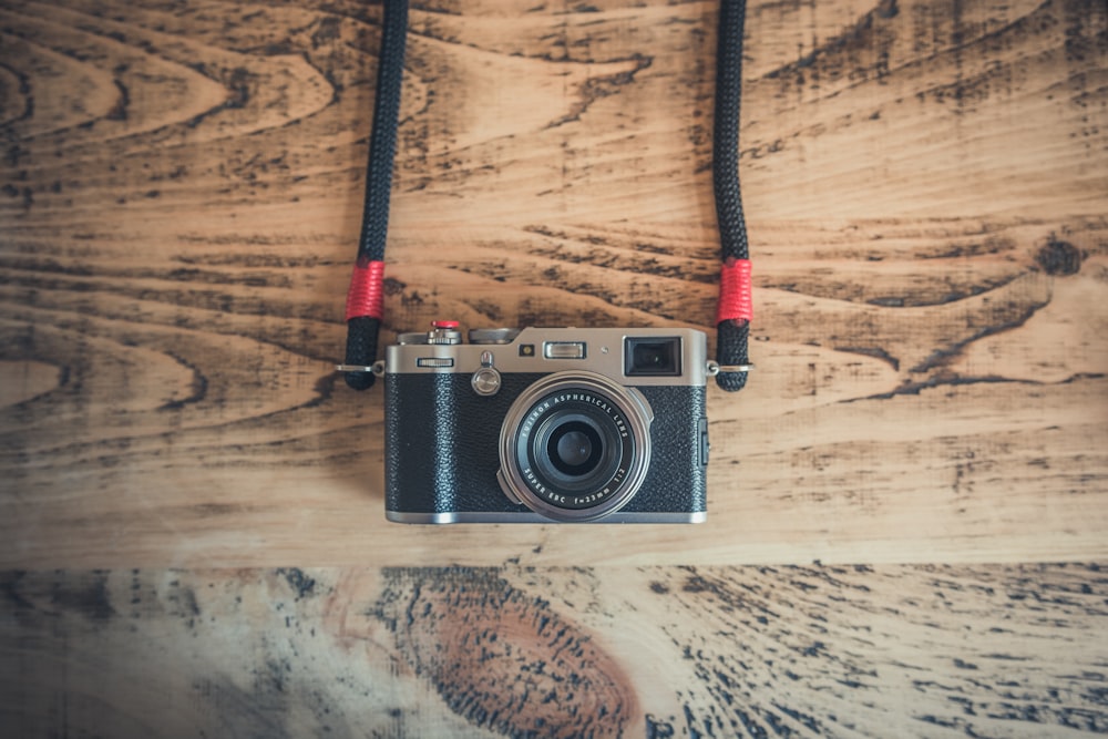 black DSLR camera on top of brown wooden surface