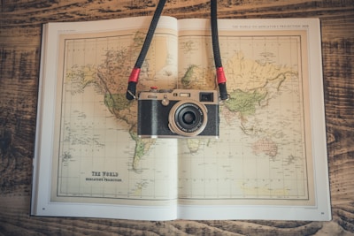 A compact digital camera resting on a travel map, ready for adventure.