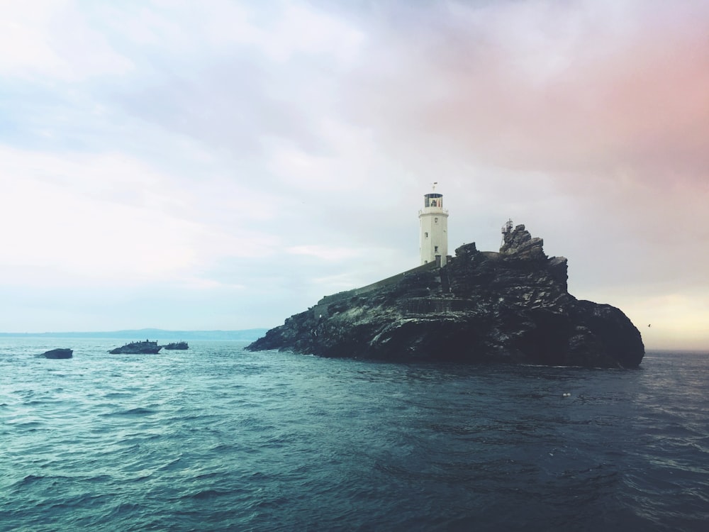 white lighthouse between body of water