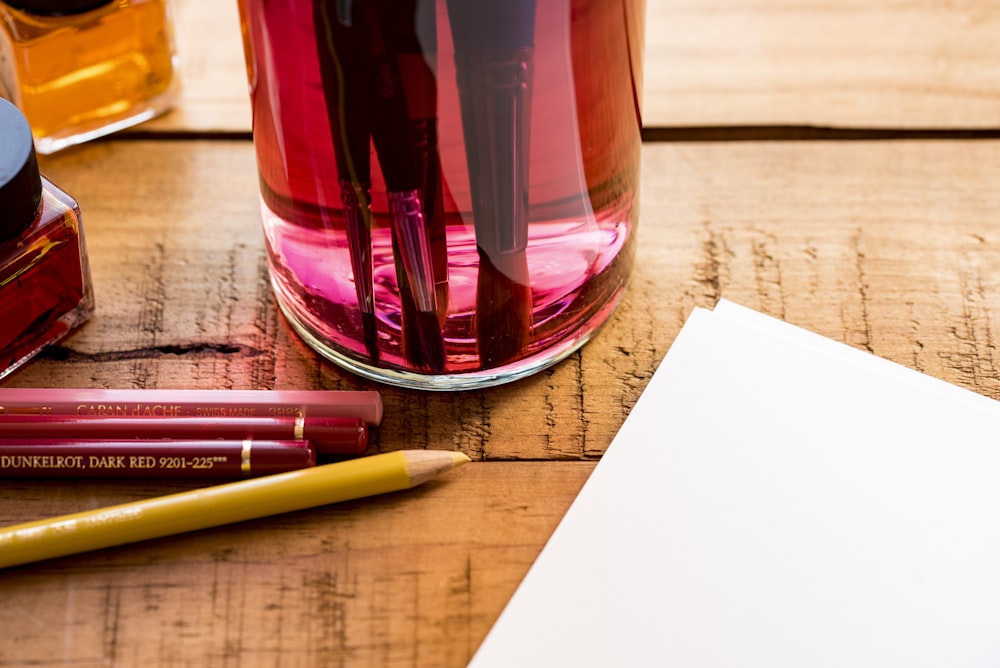 stylo de couleur à côté du papier d’imprimante blanc sur une surface en bois