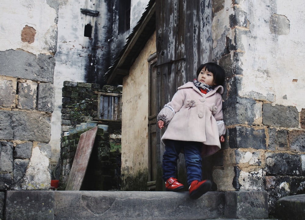 fille appuyée sur un mur de béton