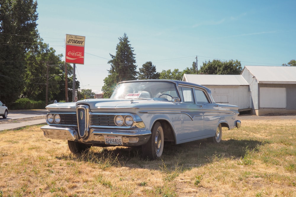 classic teal sedan near house during daytime