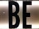 Black capital letters 'B' and 'E' against a bright, white illuminated background, possibly part of a sign or display board.