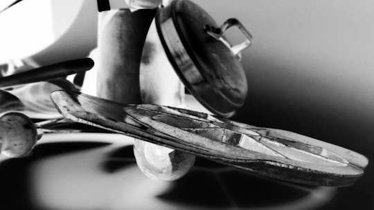Abstract shapes overlaying a silhouette of hands preparing food with a modern oven in the background.