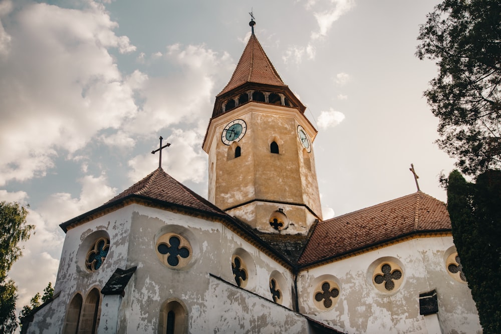 église en béton blanc et brun sous un ciel nuageux pendant la journée