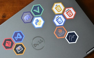 Close-up of hands coding on a laptop with eco-themed stickers.
