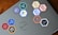 A laptop is adorned with various hexagonal stickers featuring different programming languages and tools, such as PHP, Python, JavaScript, HTML, CSS, Git, and others. The central logo on the laptop is from Dell.