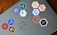 A laptop is adorned with various hexagonal stickers featuring different programming languages and tools, such as PHP, Python, JavaScript, HTML, CSS, Git, and others. The central logo on the laptop is from Dell.