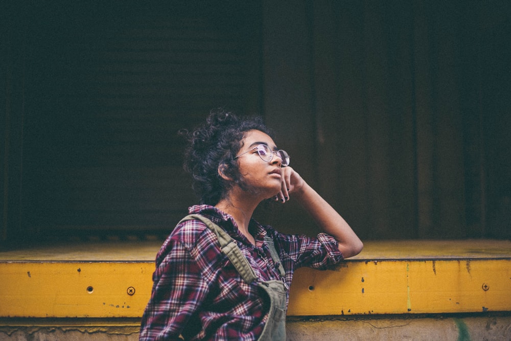 woman leaning on yellow surface