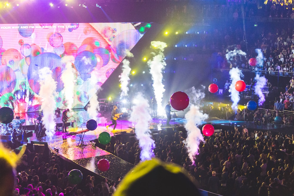 people standing near concert stage during night time