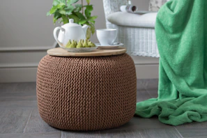 white ceramic teapot and cup on ottoman