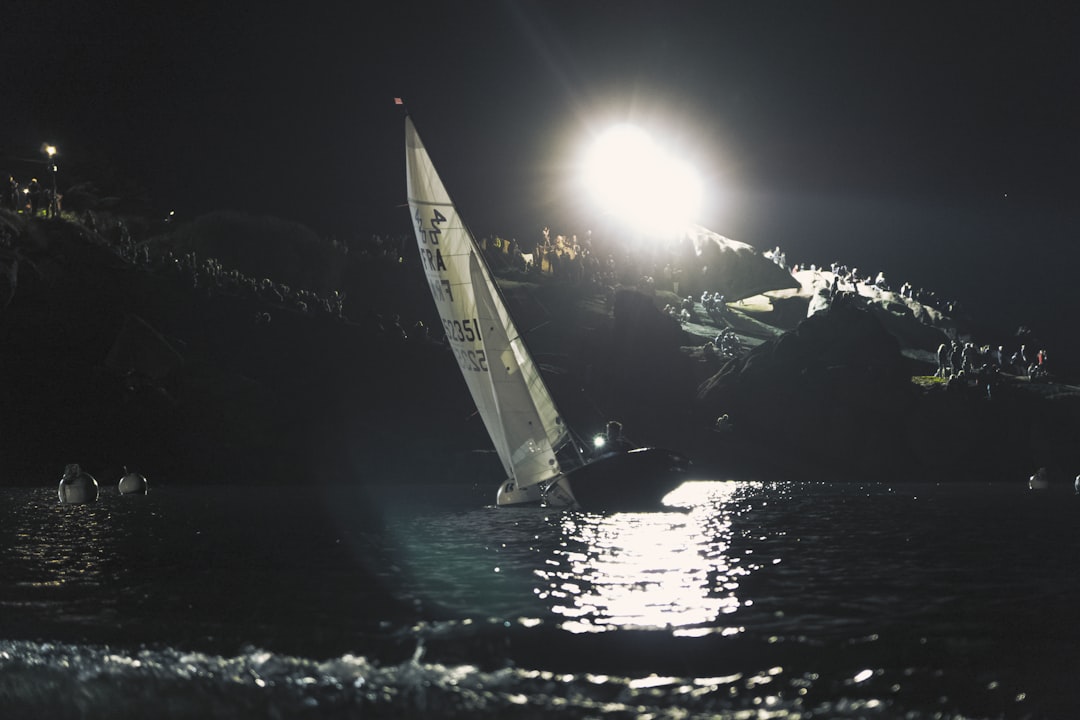 sailboat on body of water near mountain range