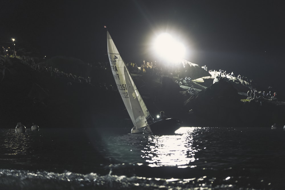 sailboat on body of water near mountain range