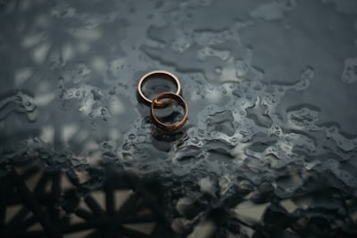 two bronze-colored rings marriage teams background