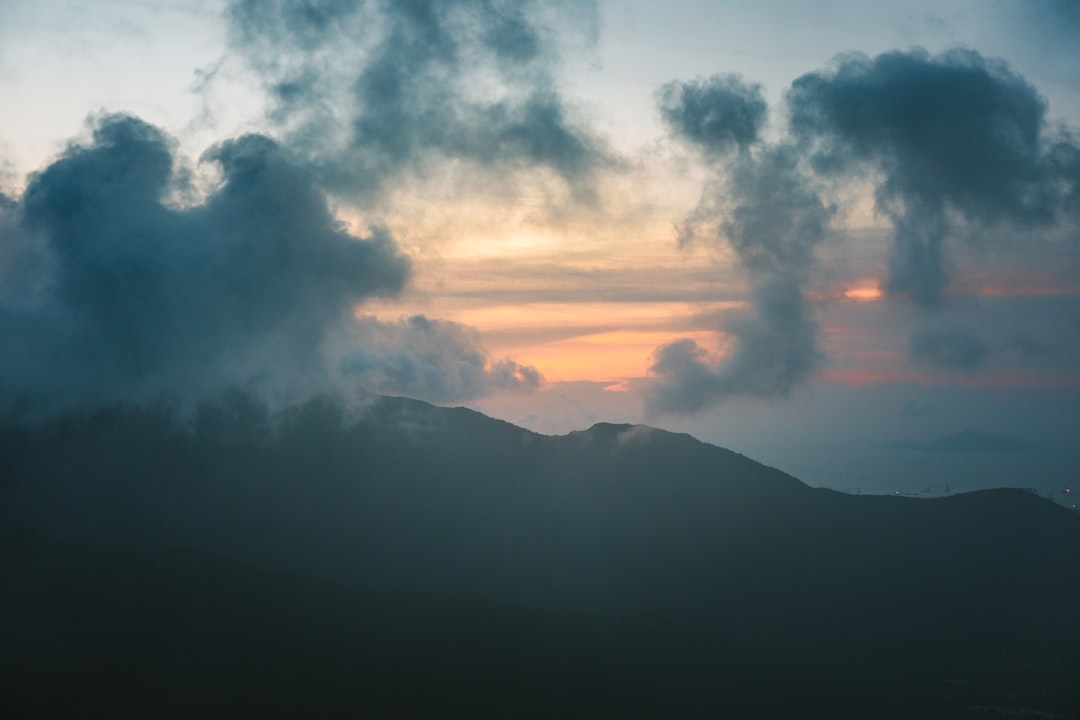 silhouette of mountain under cumulus clouds