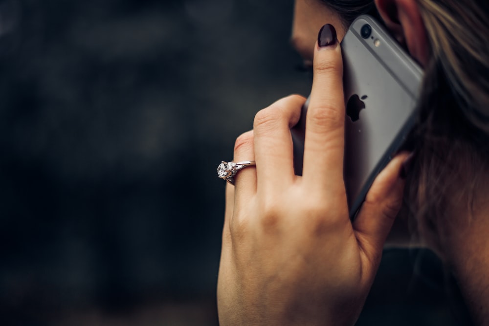 Woman wearing a diamond wedding ring talking on an iPhone