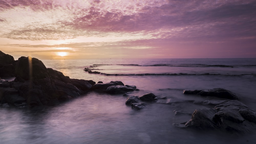 aerial photography of islet on body of water during sunset