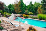 A cozy backyard with a pool and lush landscaping.