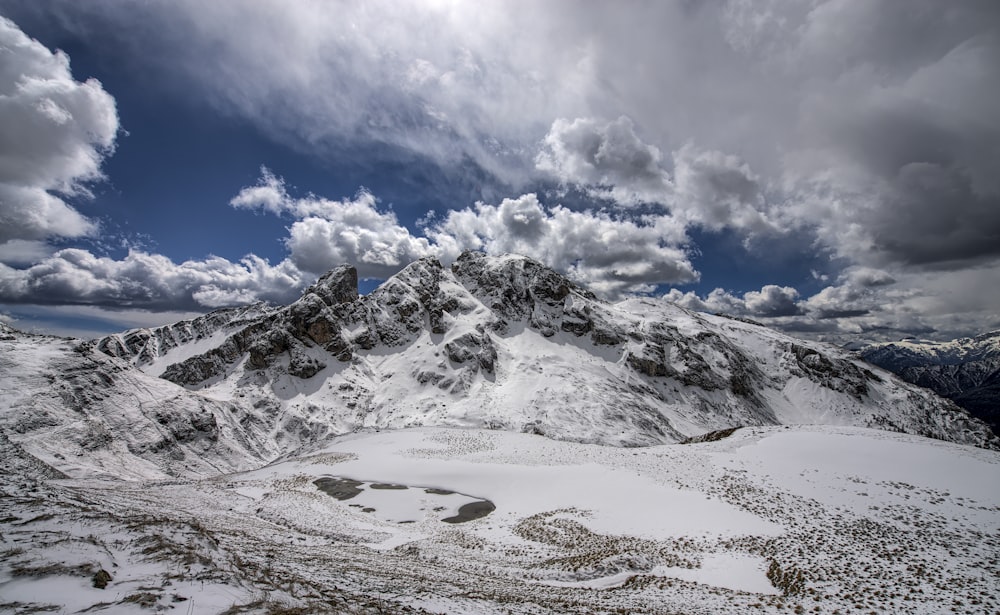 snow filled mountain under cloudy sky