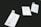 Three clothing tags with the words 'Made Wild' and 'Denver, CO' are arranged on a dark surface. The tags include size options with 'M' circled in red. Each tag has a small illustration of a running fox.