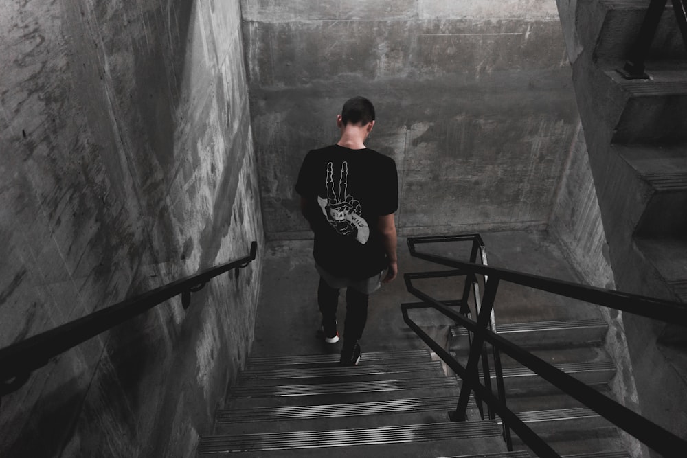 man wearing black shirt walking down the stairs