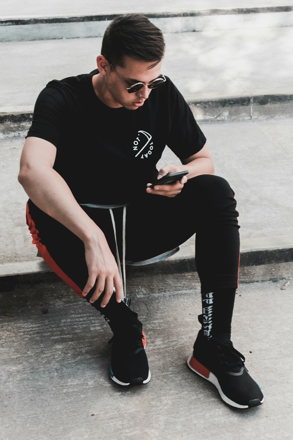 shallow focus photo of man in black T-shirt using smartphone
