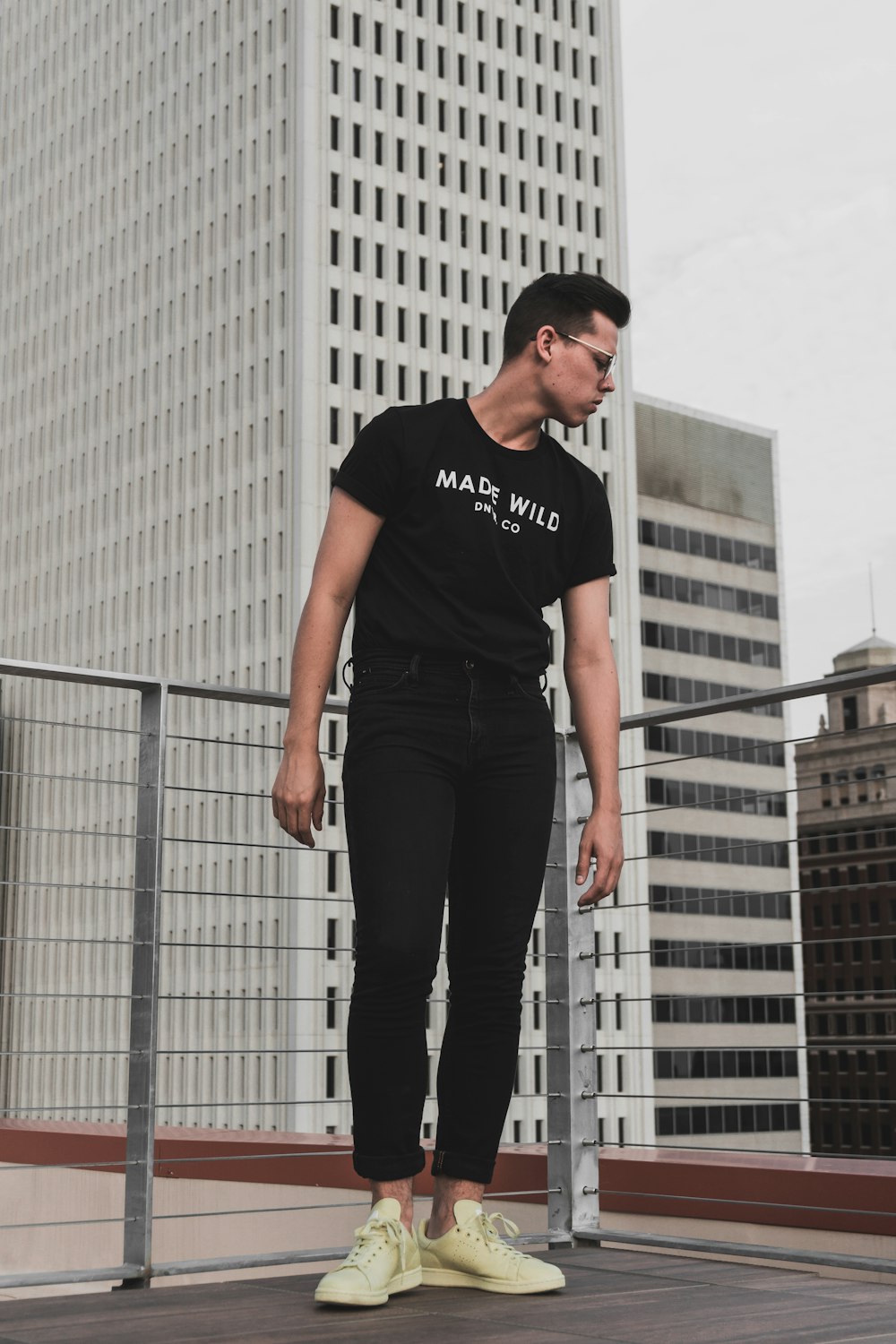 a man standing on top of a roof next to a tall building