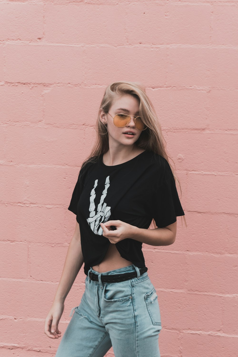 woman standing beside pink wall