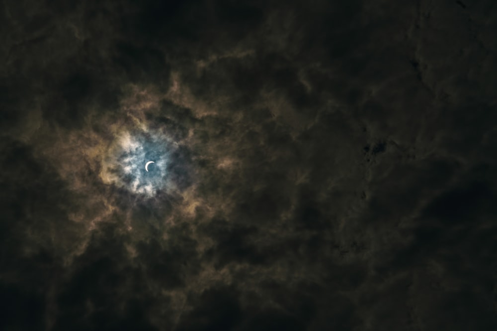 Demi-lune entourée de nuages bruns