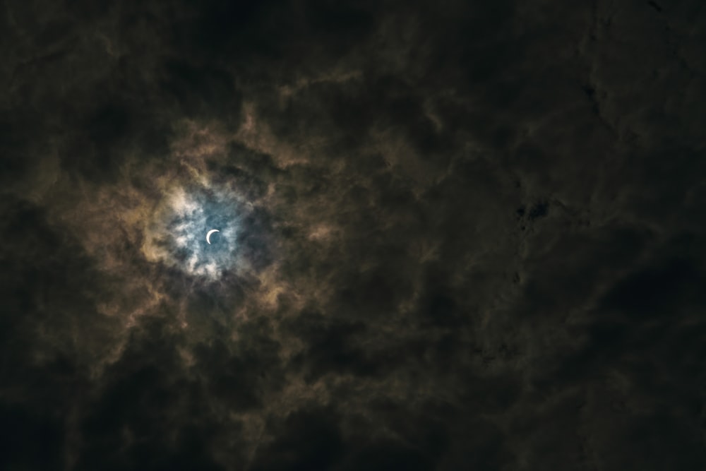 half moon surrounded by brown clouds