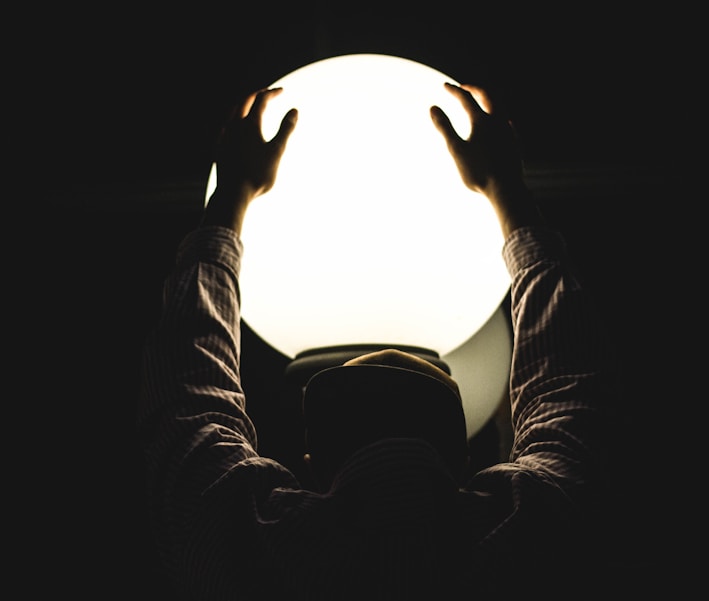 person holding round glass window by Justin Clark (https://unsplash.com/@imjustintime)