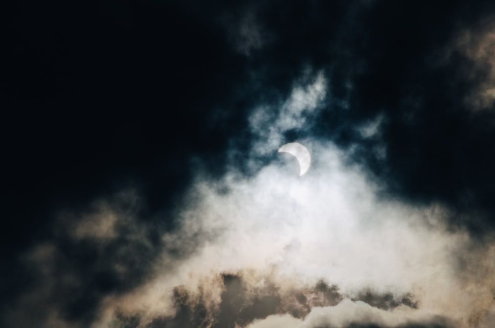 meia lua escondida no céu nublado branco e preto