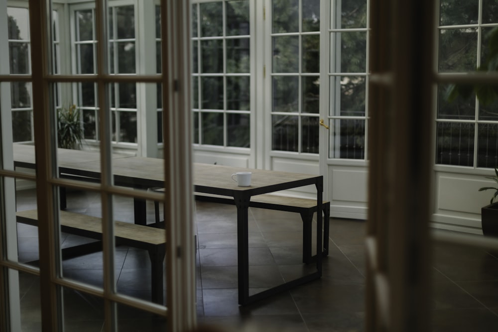 brown wooden table beside glass paneled wall