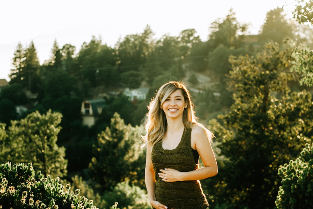 woman standing in front of trees during sunset