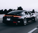 running black Porsche sedan