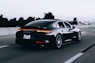 running black Porsche sedan