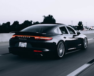 running black Porsche sedan