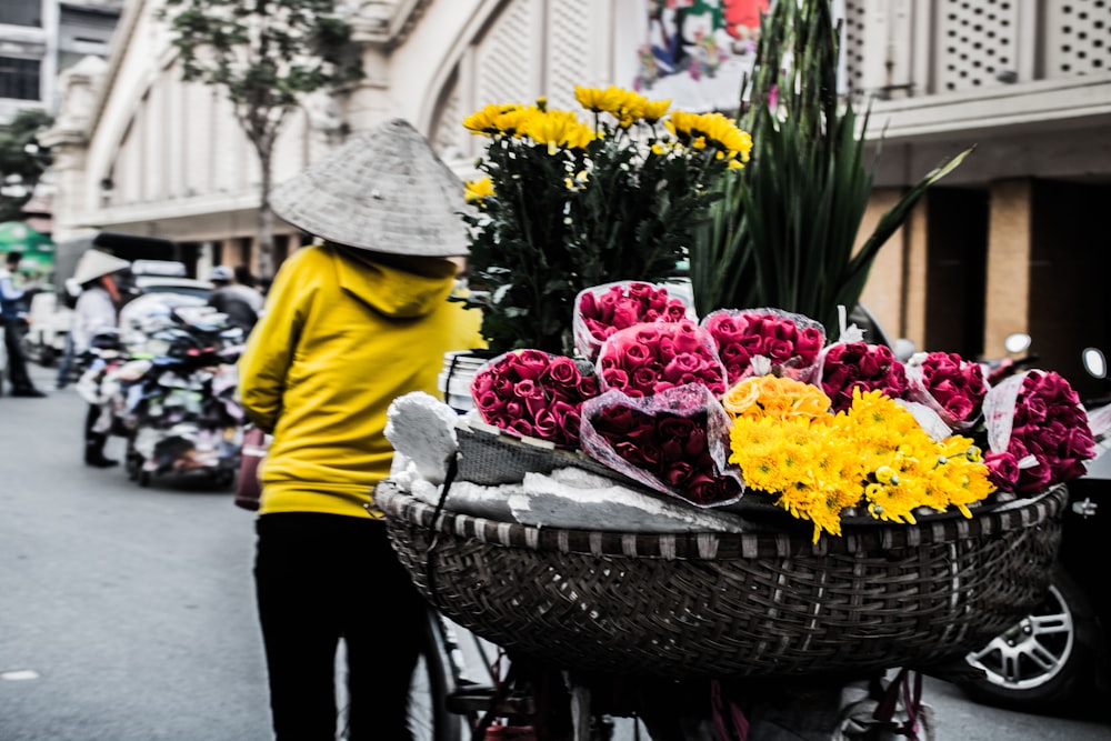 A woman pulling a cart full of flowers.