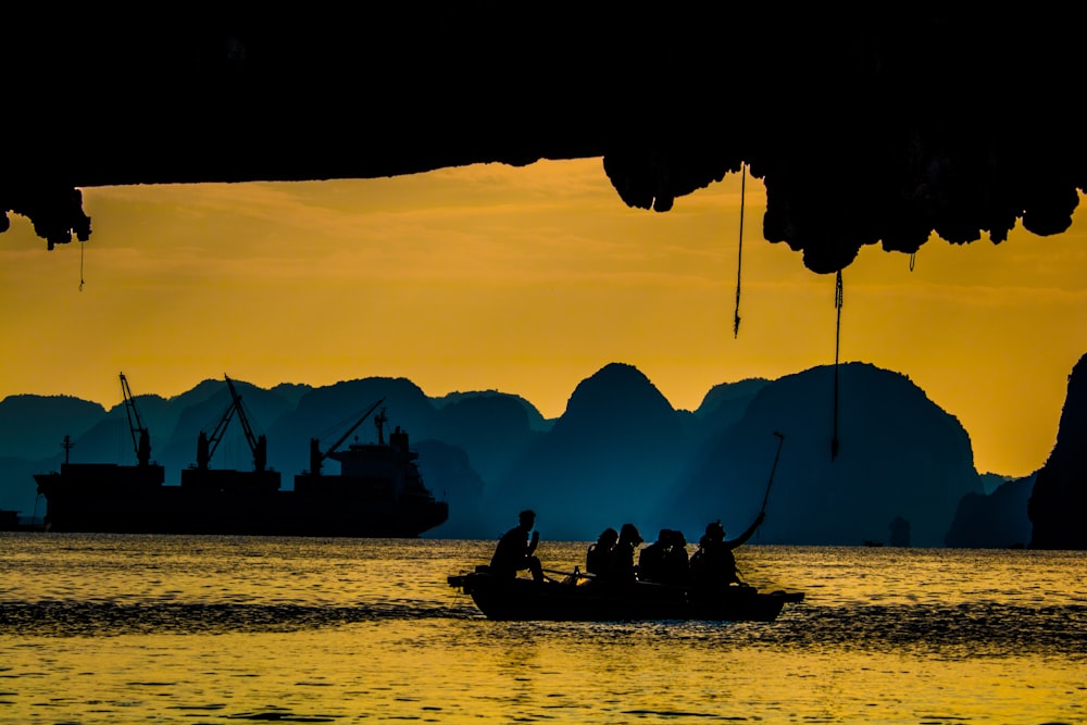 gruppo di silhouette di persone che cavalcano sulla barca