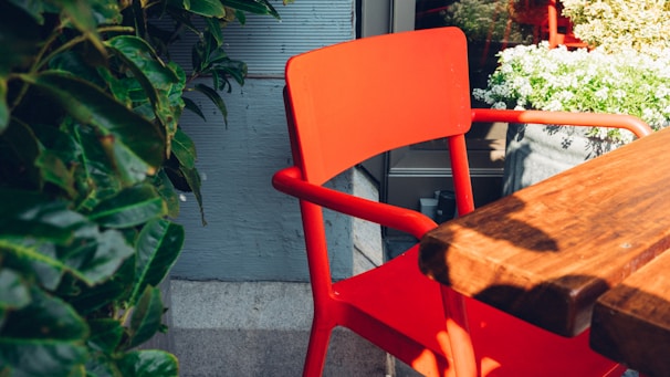 A vibrant red dining chair with a slim metal frame in an airy kitchen.