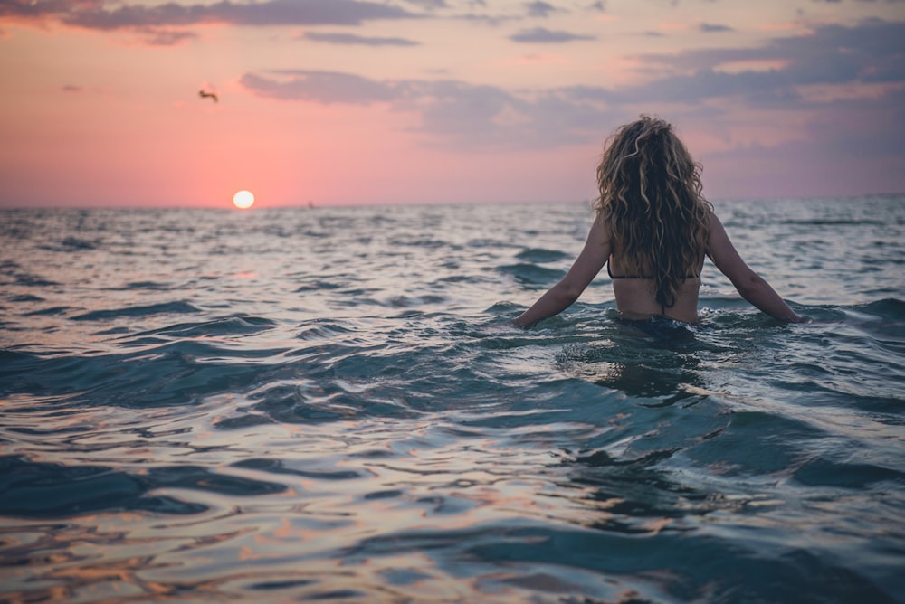 mujer nadando en el cuerpo de agua