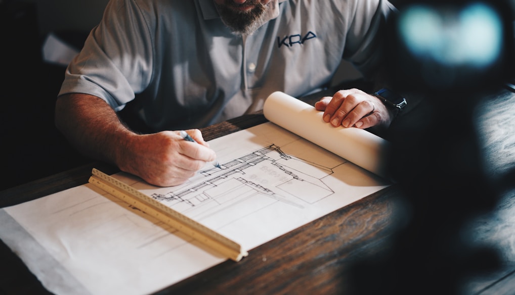 An architect working on a draft with a pencil and ruler