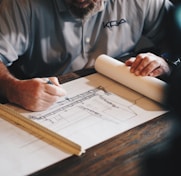 An architect working on a draft with a pencil and ruler