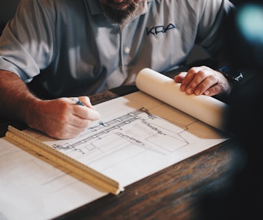 An architect working on a draft with a pencil and ruler