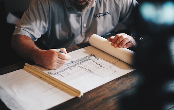 An architect working on a draft with a pencil and ruler