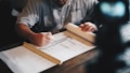 An architect working on a draft with a pencil and ruler