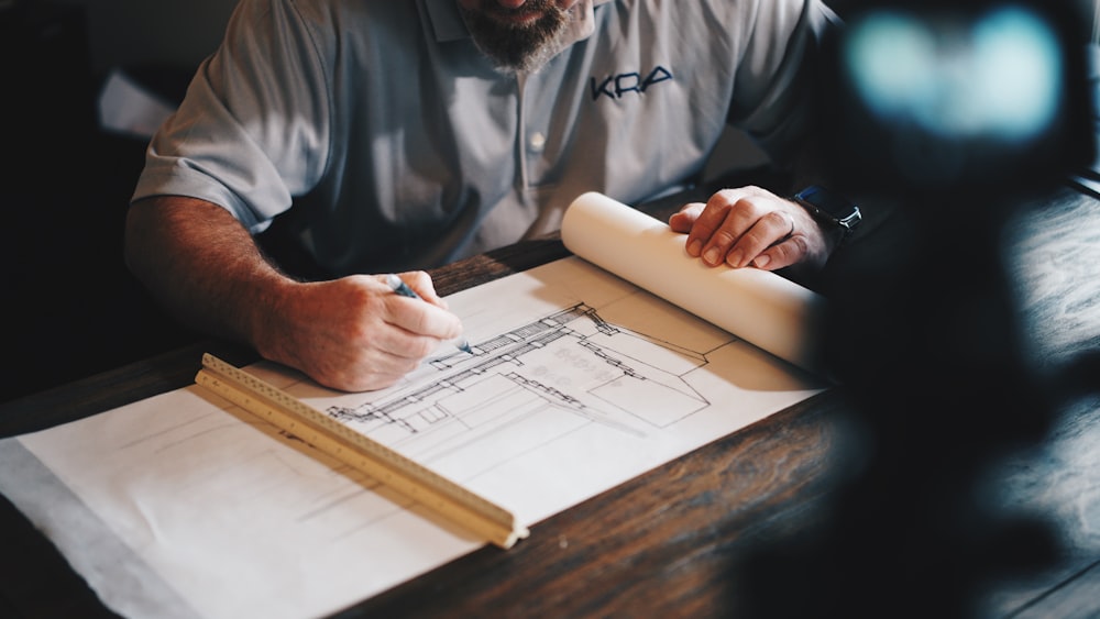 An architect working on a draft with a pencil and ruler