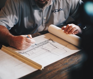 An architect working on a draft with a pencil and ruler