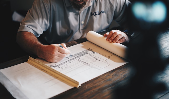 An architect working on a draft with a pencil and ruler